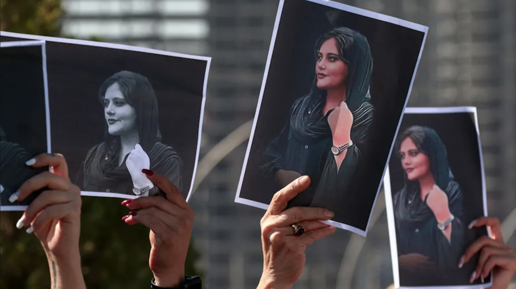 Protesters hold photos of Mahsa Amini