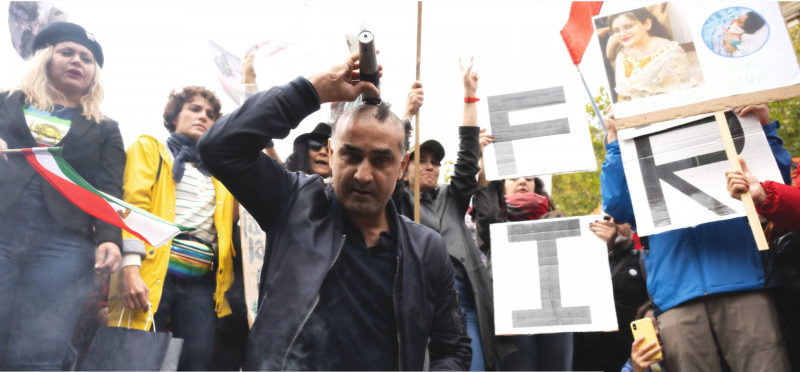 Man shaves his head at a protest